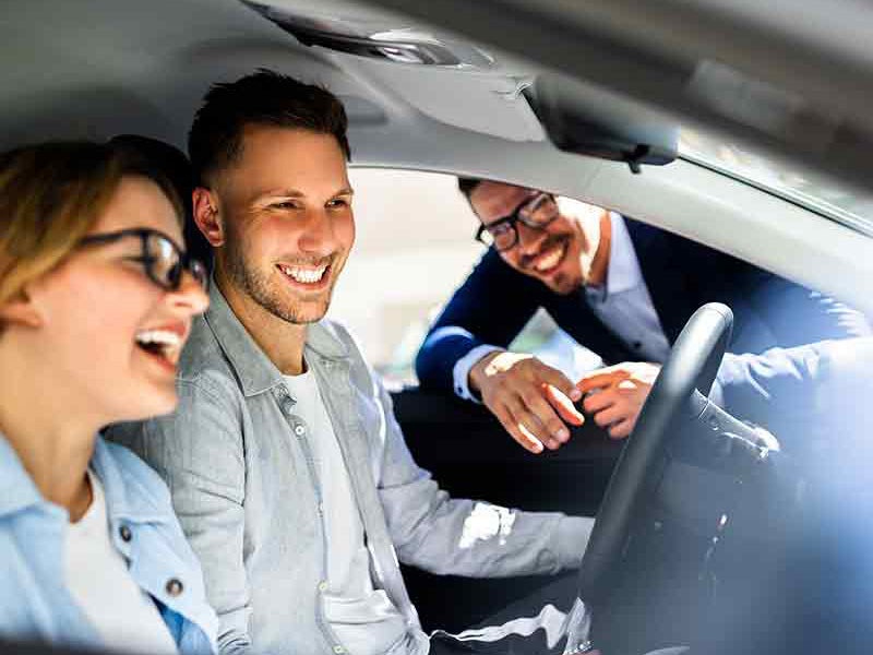 couple sitting in a car in the showroom of Alexandria Chevrolet Cadillac in Alexandria MN 