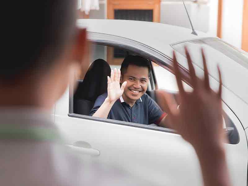 customer waving at sales rep at Alexandria Chevrolet Cadillac in Alexandria MN 