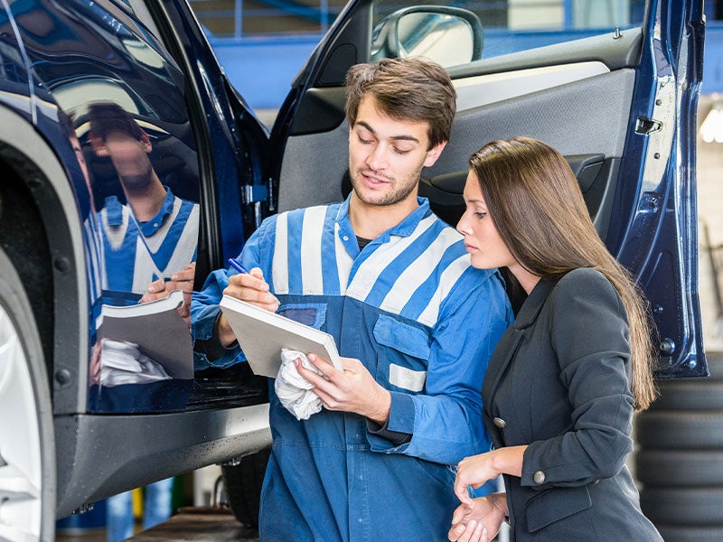 service technician going over items with customer at Alexandria Chevrolet Cadillac in Alexandria MN 